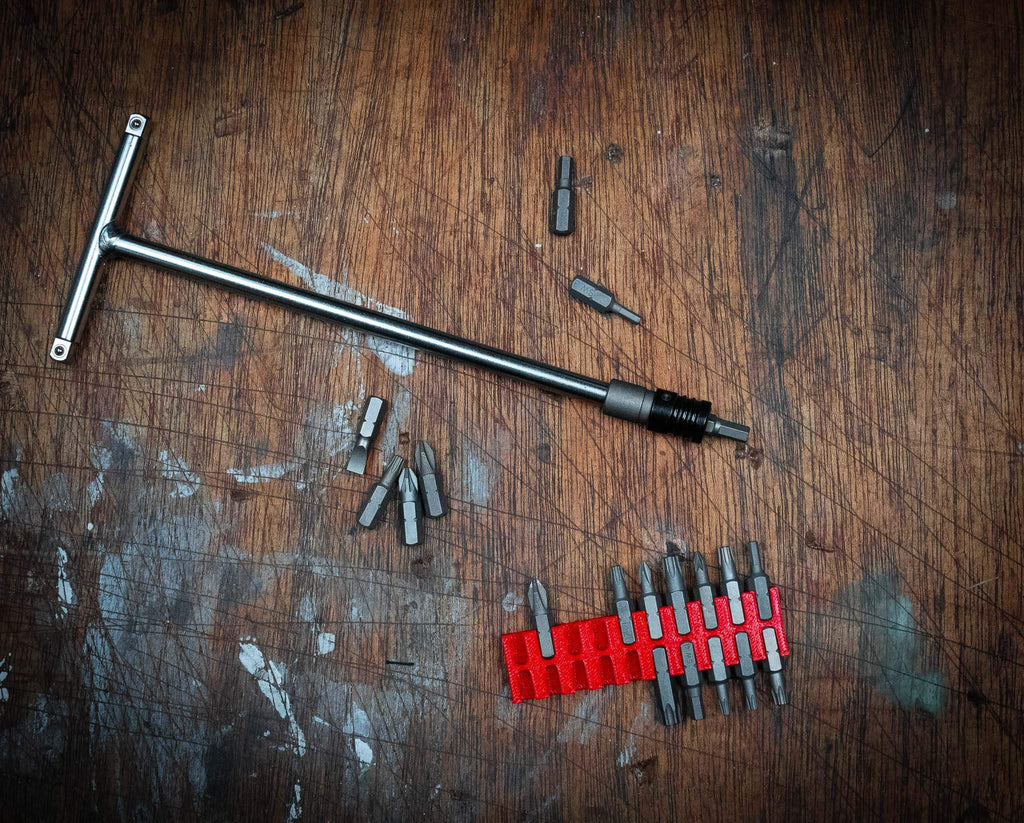 1/4" adaptor with quick-release bit chuck and multiple drill bits on wooden surface