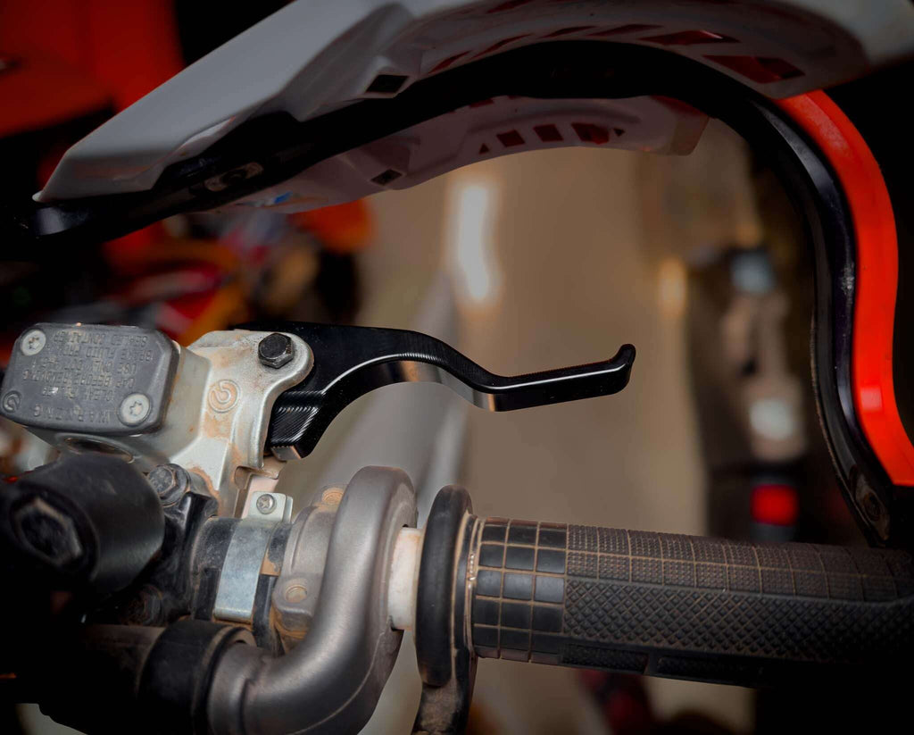 Easy-pull shorty clutch and brake lever on a motorcycle handlebar designed to reduce finger fatigue and improve endurance during racing.